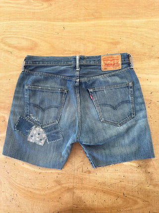 Blue denim shorts with a brand label on a wooden surface
