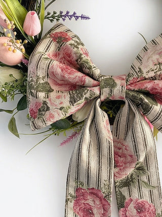 Floral wreathe with a bow on a white background with flowers.