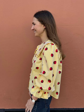 Side view of ethically made blouse showing frilled neckline and soft puffed sleeves.