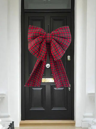 Black door with a large red plaid bow decoration