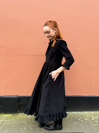 women in black dress side view
