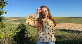 women in frield wearing Eco-friendly women’s blouse with playful strawberry pattern.