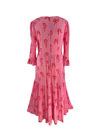 Elegant pink bow dress on a mannequin, featuring sustainable fabric and a timeless design