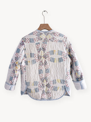 Floral patchwork shirt on a hanger against a white background