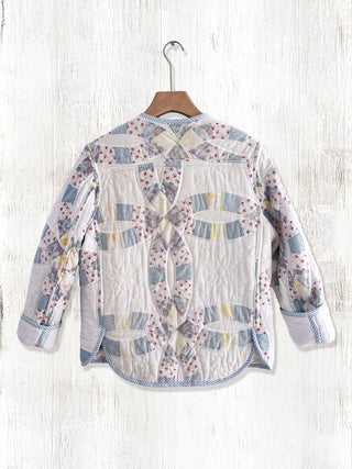 Floral patchwork shirt on a hanger against a white wooden background