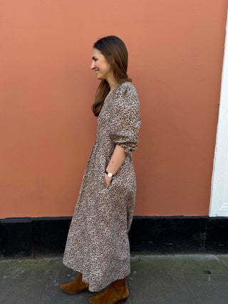 Side profile of eco-conscious leopard print midi dress with flattering V-neck and soft drape.