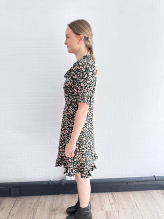 Side view of sustainable floral mini dress with ruffle hem, crafted in the UK.