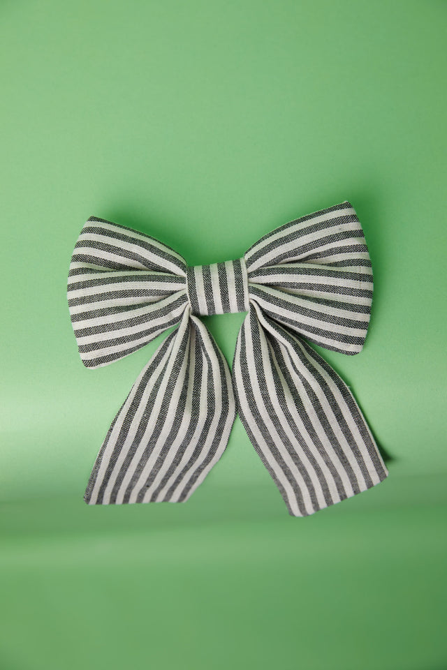 The Well Worn ticking stripe bow on green background