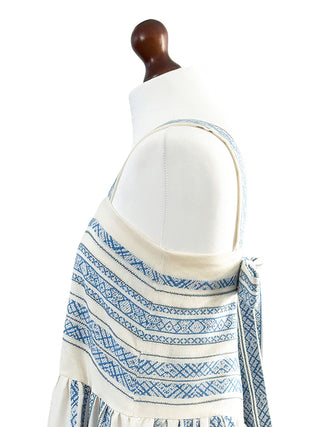Mannequin wearing a white dress with a blue patterned shawl draped over the shoulders on a white background