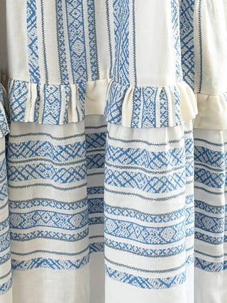 White curtains with blue geometric patterns hanging side by side.