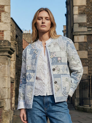 model wearing vintage blue quilt jacket by stone building