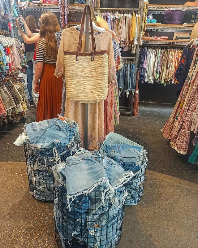 denim shorts piled up in baskets in vintage store