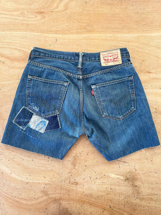 Blue denim shorts with Levi's branding on a wooden surface