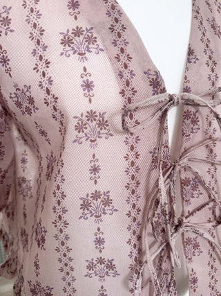 Close-up of a pink floral patterned dress with a tie detail.