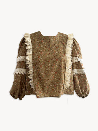 Patterned blouse with lace trim on a white background