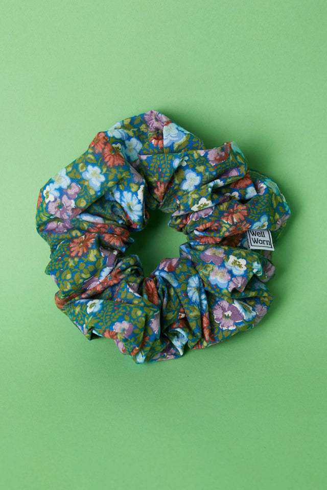 The Well Worn floral scrunchie on green background