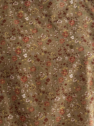 Floral patterned fabric with small flowers on a beige background