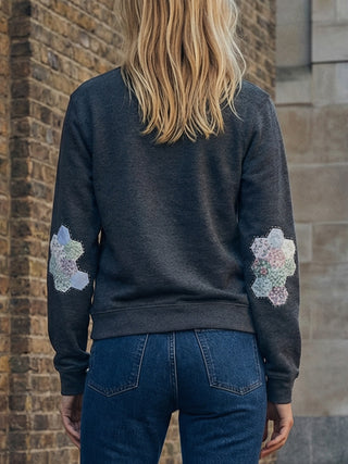 back woman wearing patchwork sweatshirt
