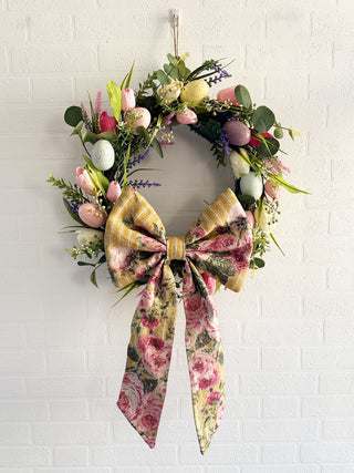 Large padded fabric bow on a floral Easter wreath, designed for sustainable home decor and ethically handmade in the UK