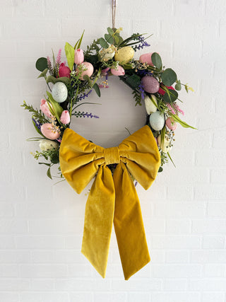 Softly padded oversized fabric bow on a floral spring wreath, made from sustainable materials for eco-conscious decor