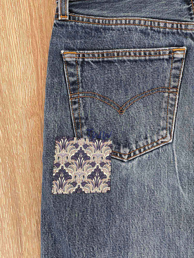 The Well Worn patched-jeans-on-floor-back-pocket